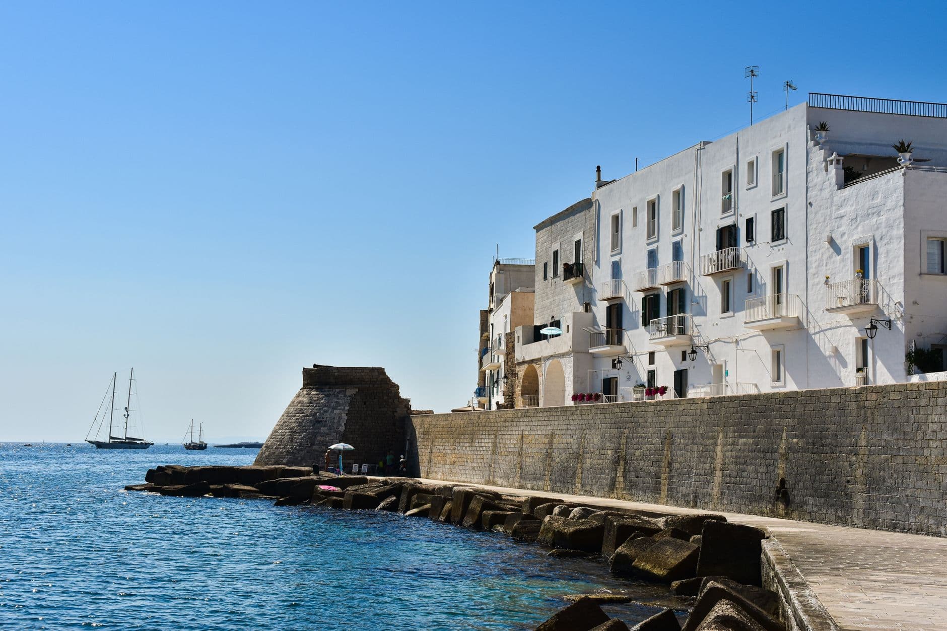 Le vieux port de Monopoli et ses barques de pêche colorées au pied des remparts
