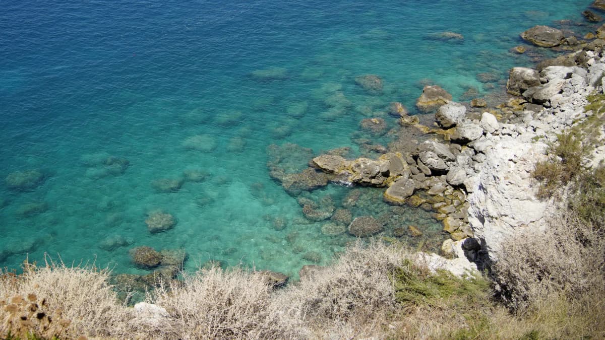 Explore the clear blue waters and rocky coastline of San Nicola di Tremiti in Puglia, Italy.